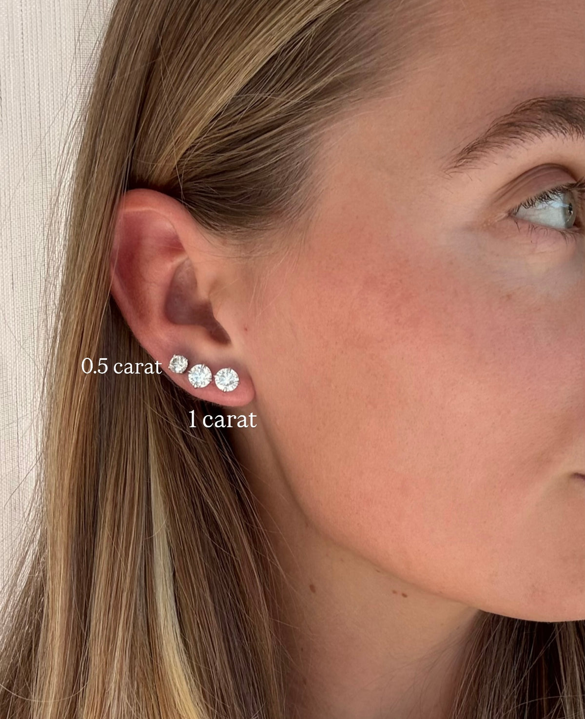 Close-up of a woman's ear wearing daily diamonds diamond stud earrings with size labels.